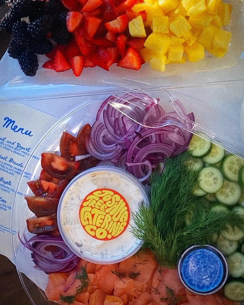 Crew breakfast platters: fruit, smoked salmon with cucumber, red onion, tomato and dill, and a tub of dill cream cheese with the JTCC sticker