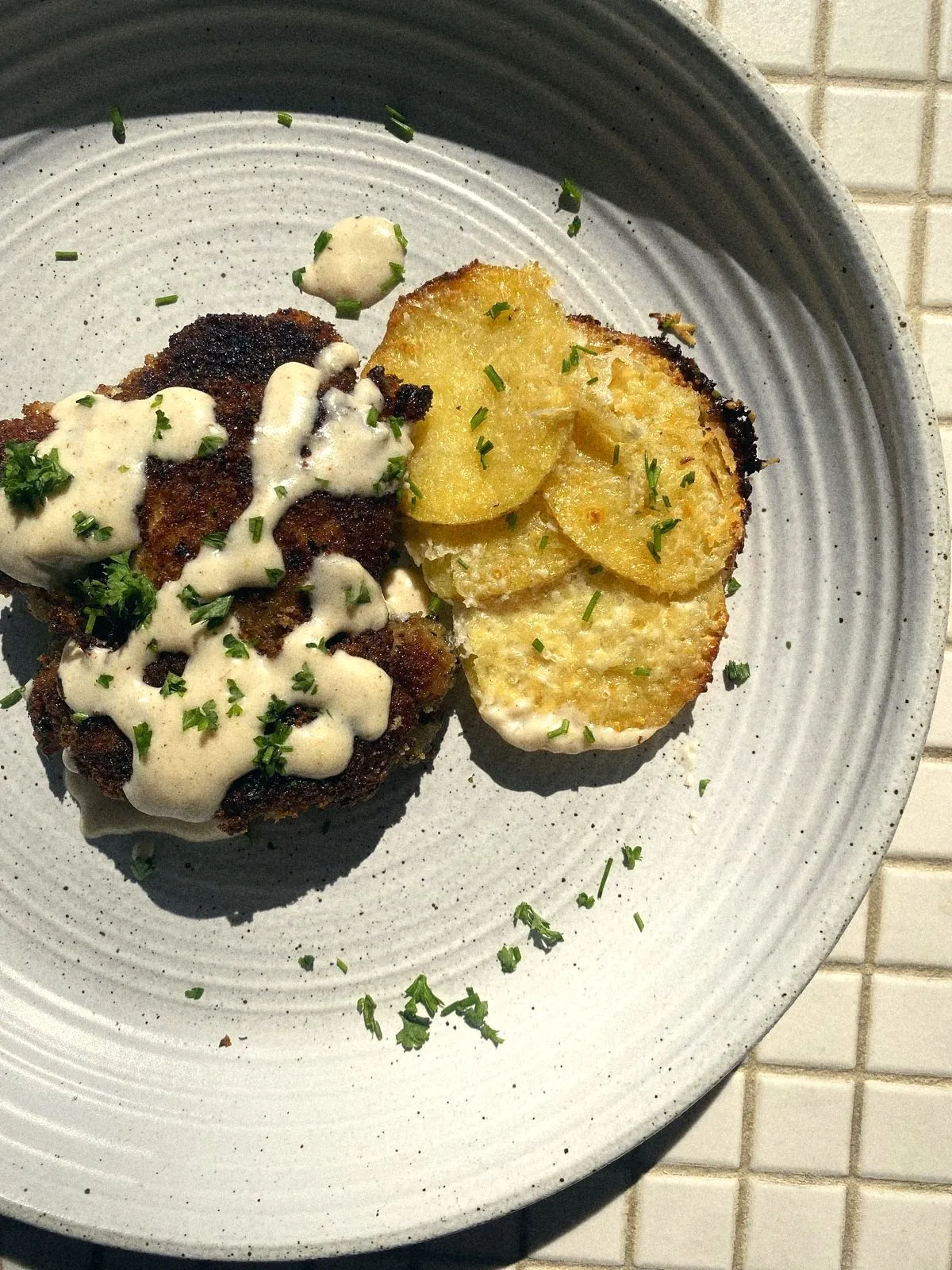 Crab cakes with herbed cream and crispy potato gratin