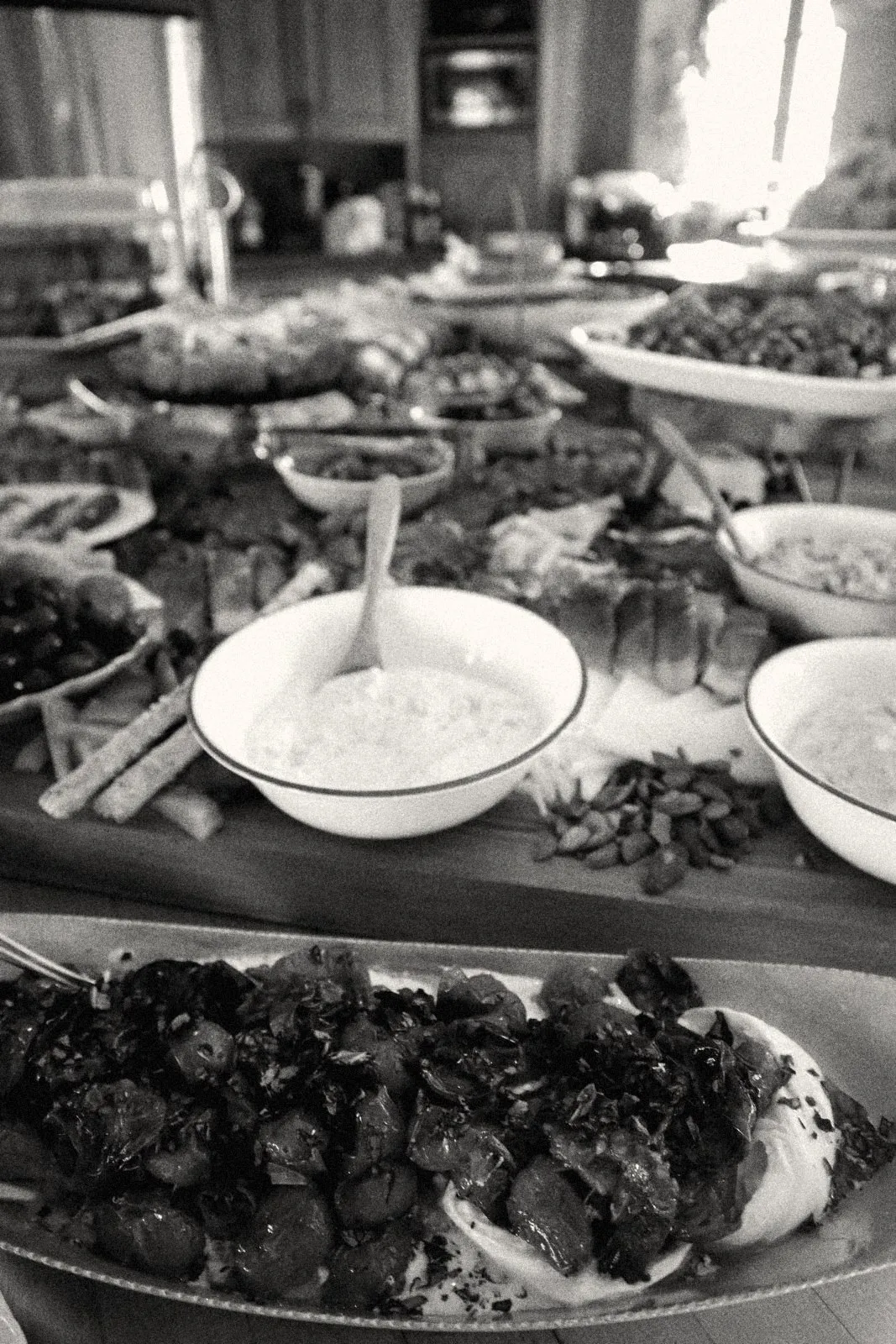 A grazing table: roasted tomatoes over burrata, cured meats, cheeses, dips and olives