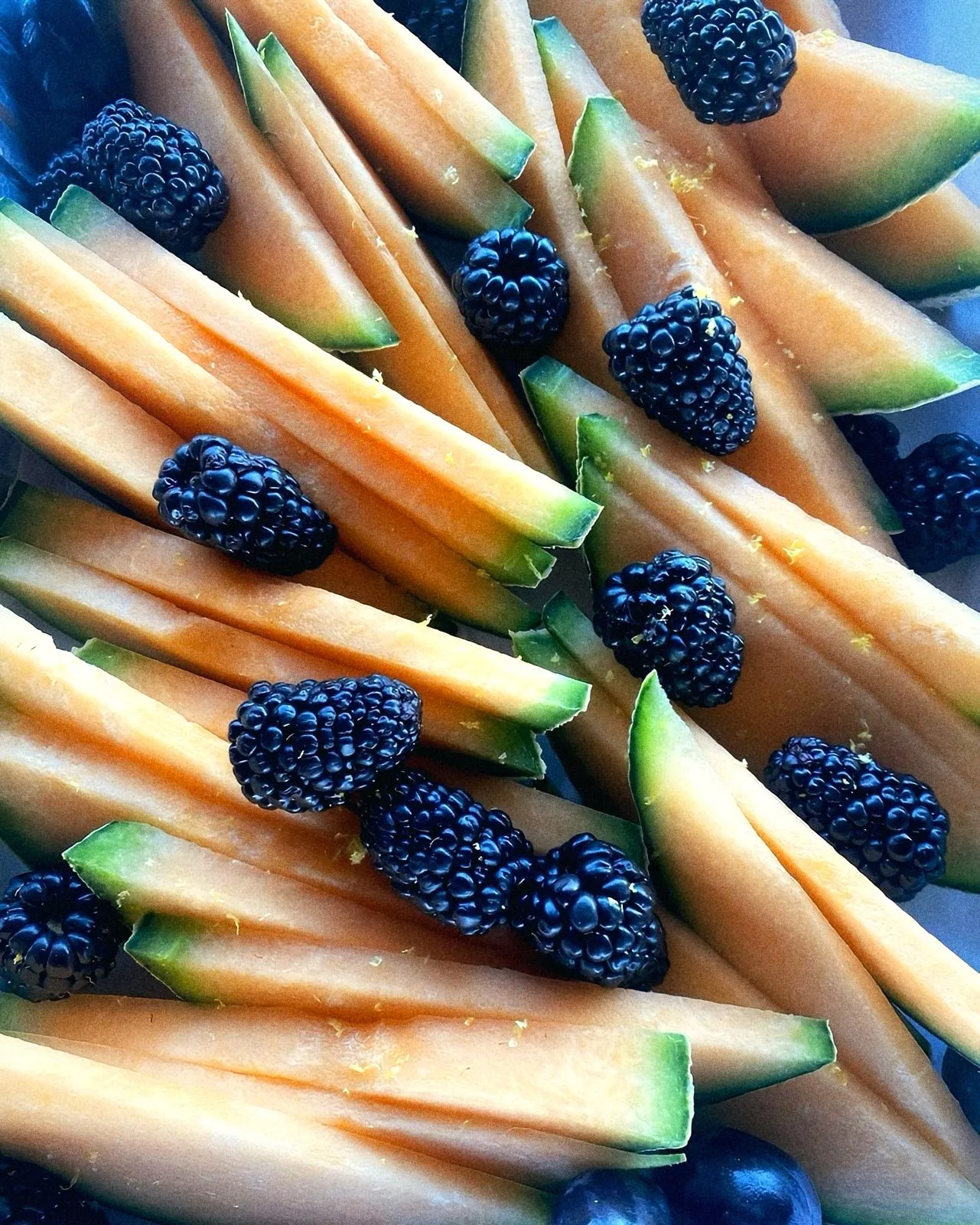 Cantaloupe spears with blackberries and lemon zest