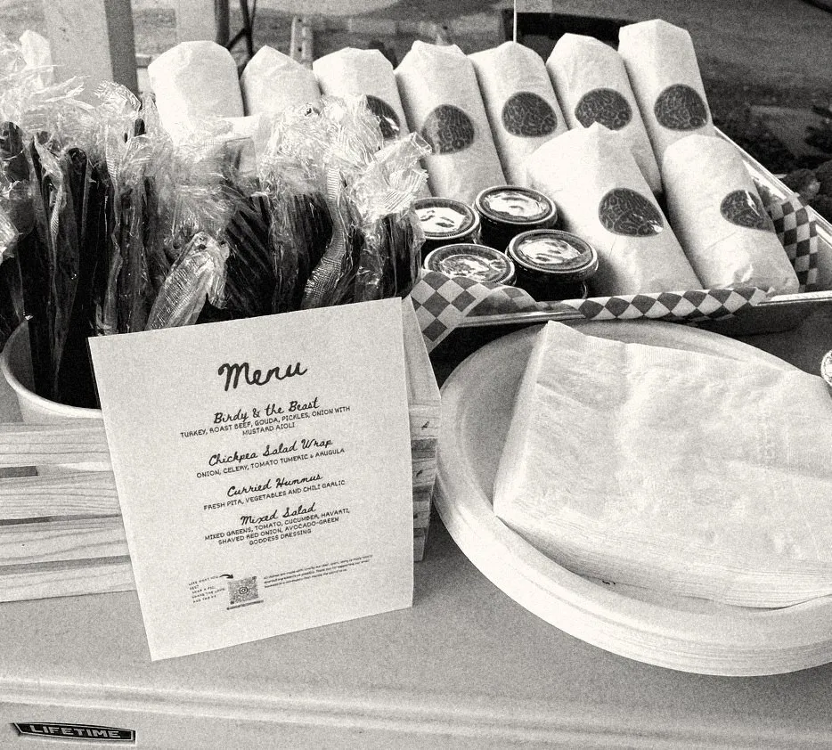 A printed menu at a production lunch: wraps, curried hummus, mixed salad