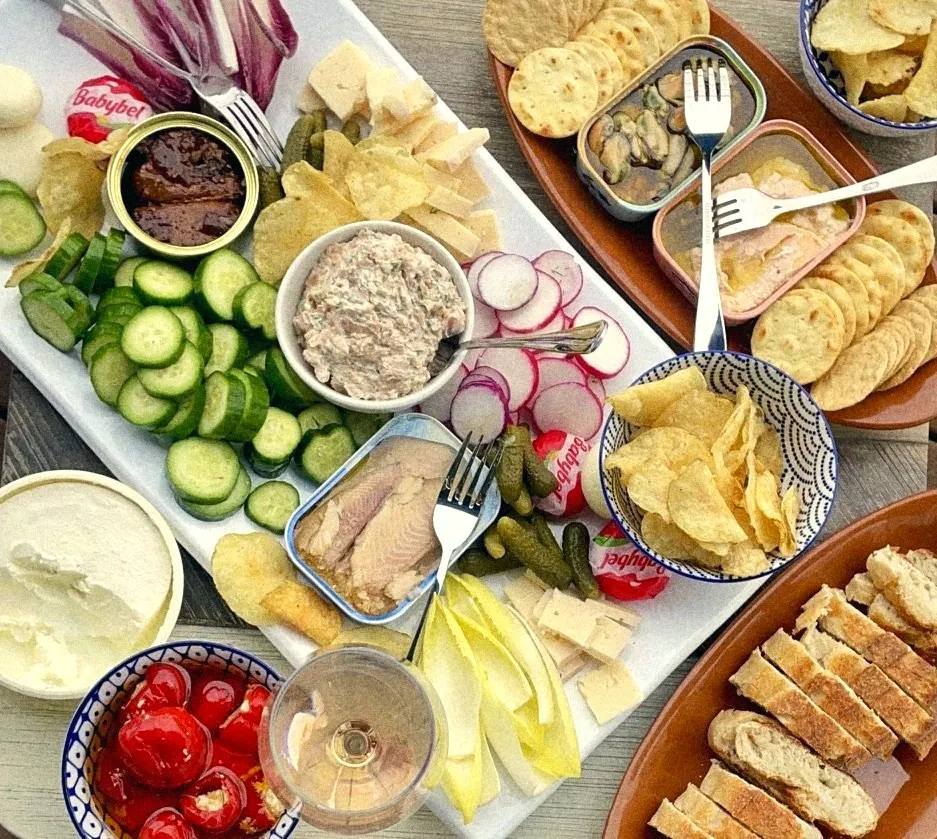 A tinned fish spread with cucumbers, radishes, chips and rosé